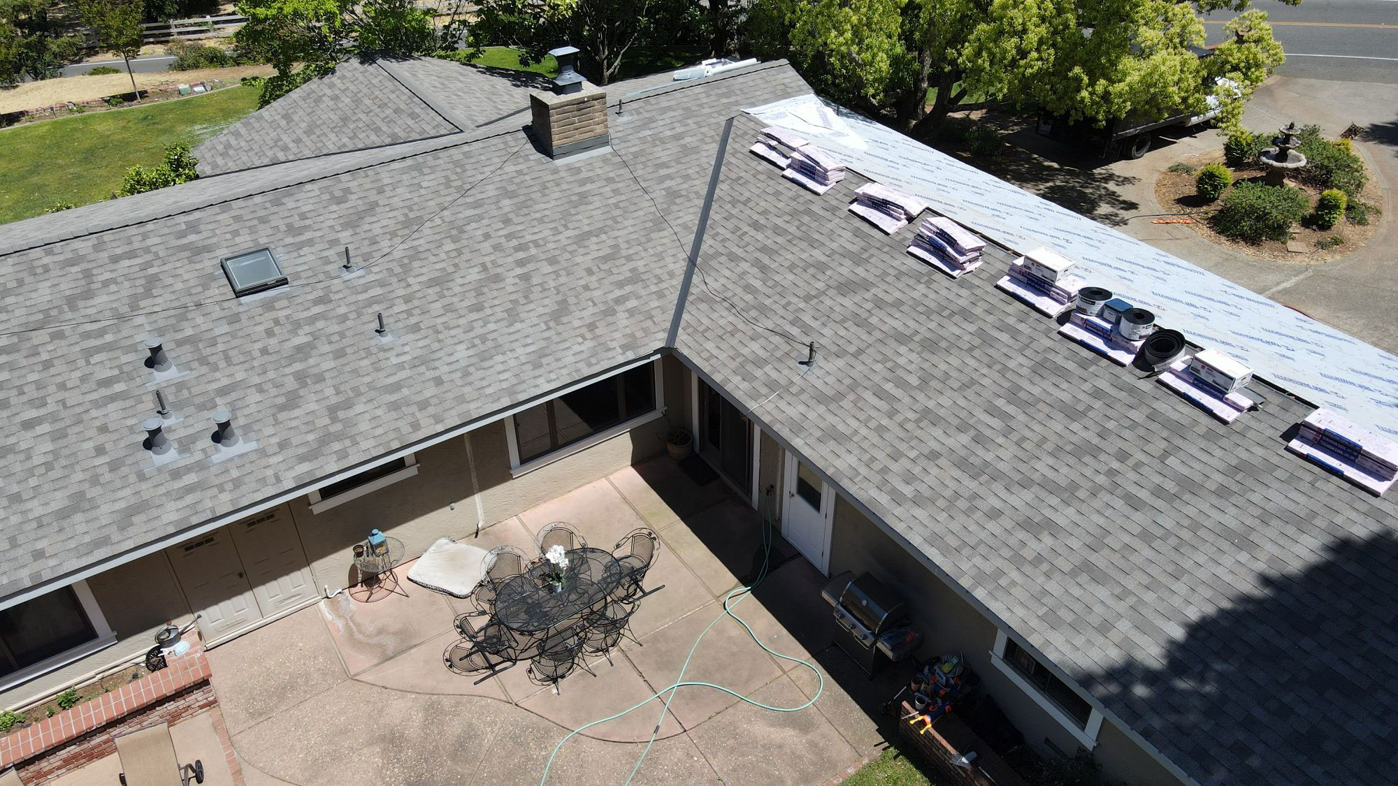 The image shows a residential house with a sloped roof featuring solar panels, viewed from an elevated angle.