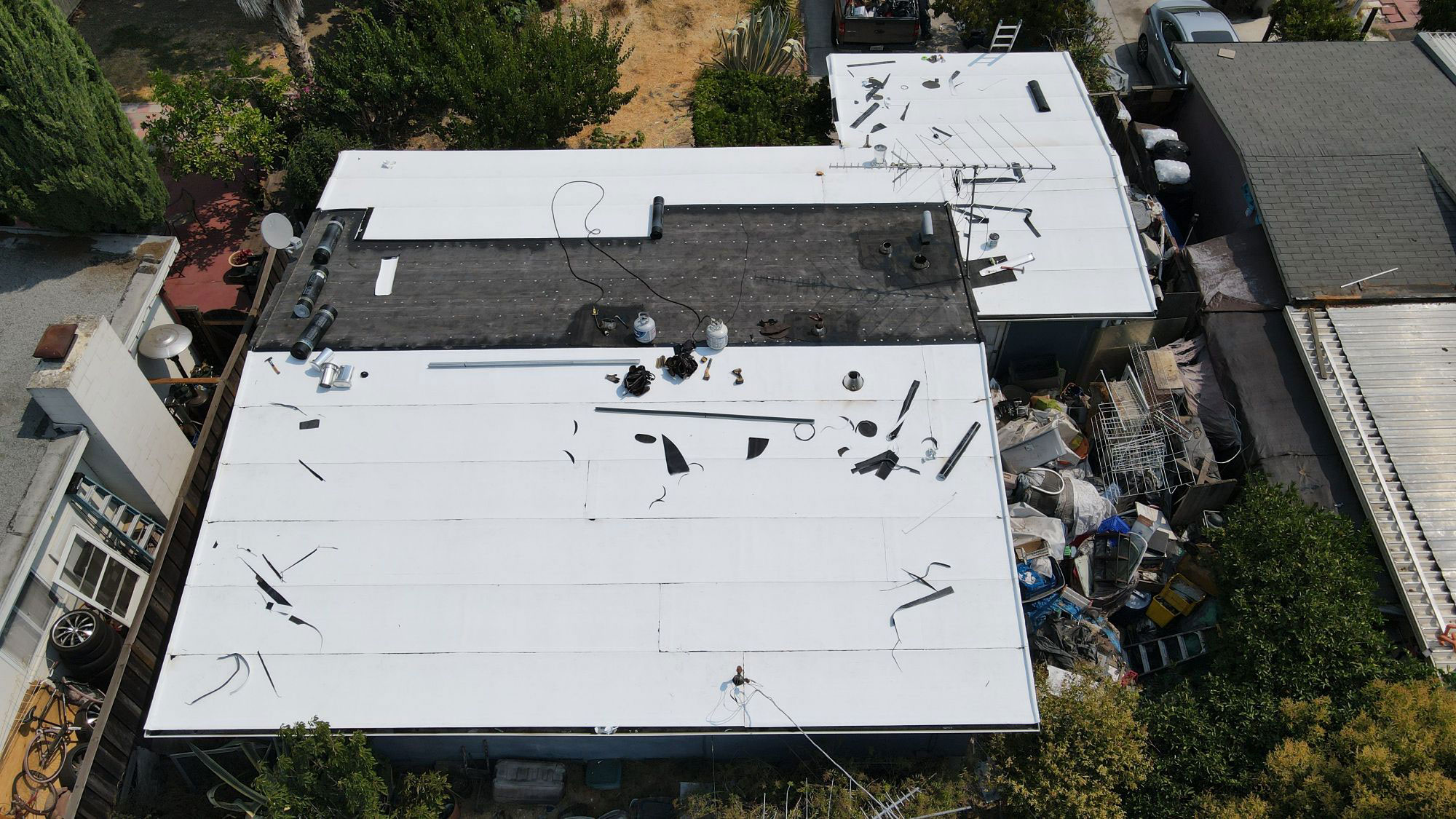 The image depicts a roof with visible damage, possibly from a recent storm or event, with debris scattered on top.