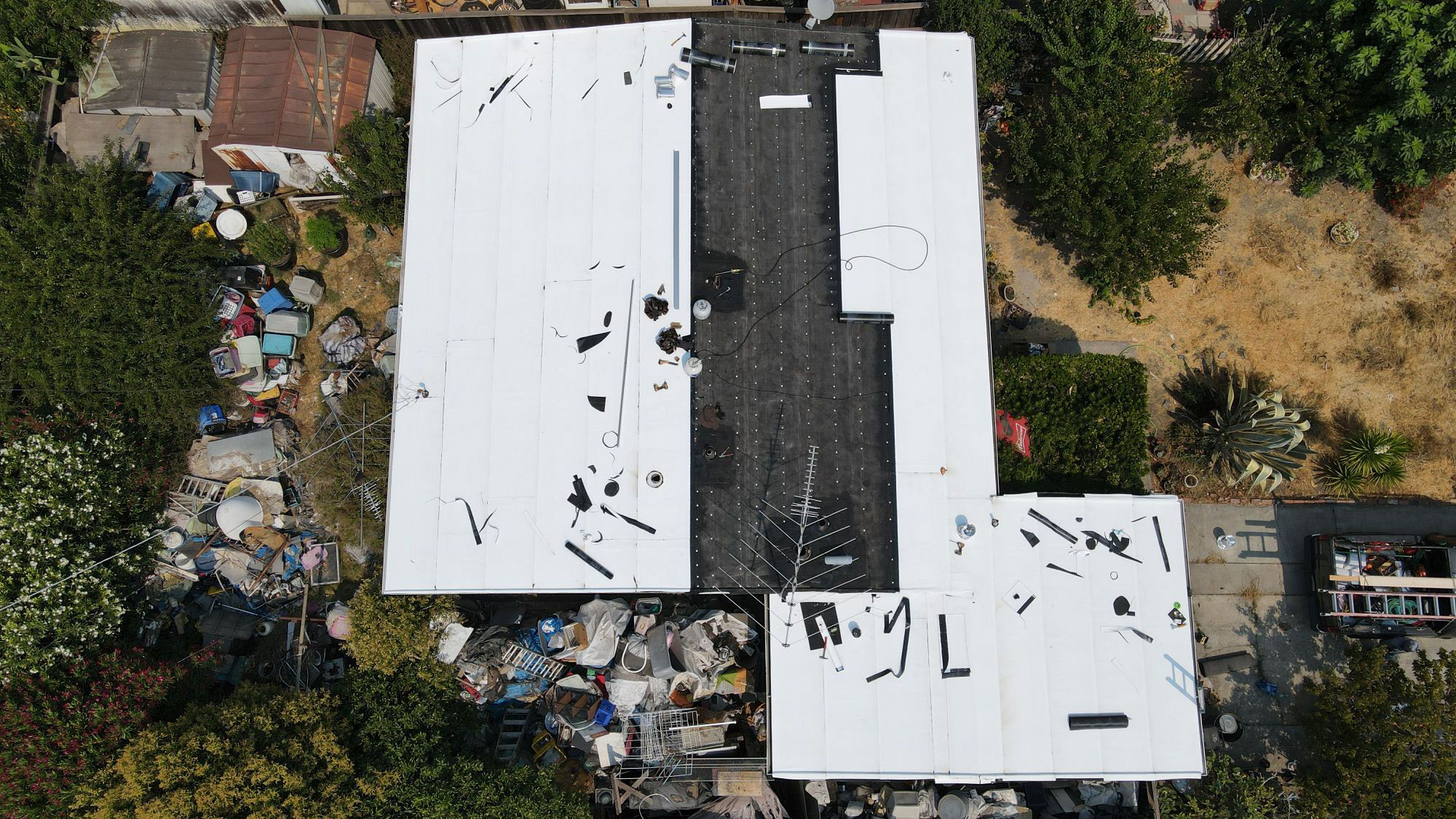 The image shows a building with a damaged roof, under which there appears to be some debris scattered on the ground.