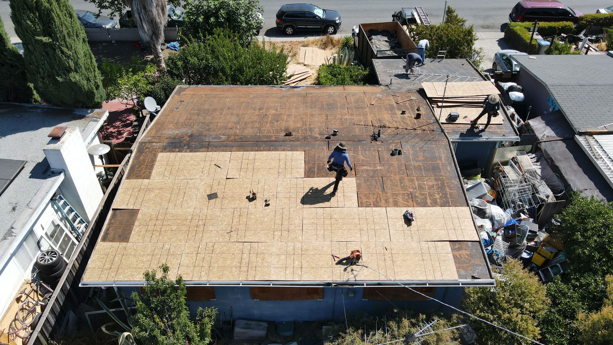 An under-construction rooftop with workers present.