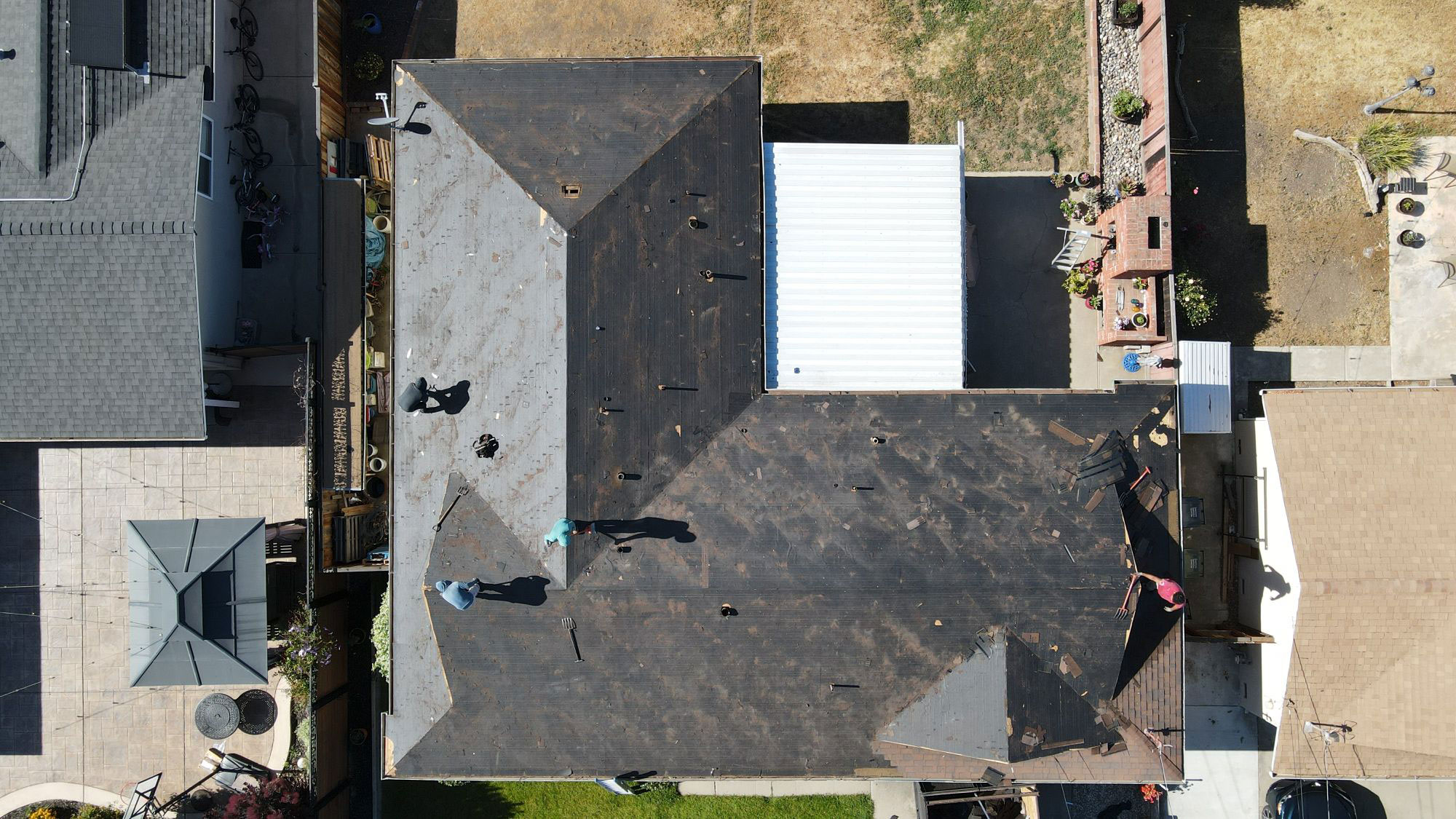 Aerial view of a residential area showing a roof under construction with workers on site.
