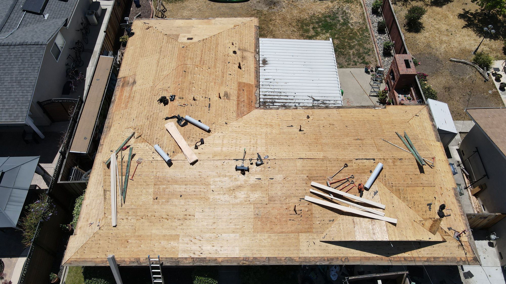 The image shows a building under construction with exposed wooden beams on the roof, indicating ongoing renovation work.