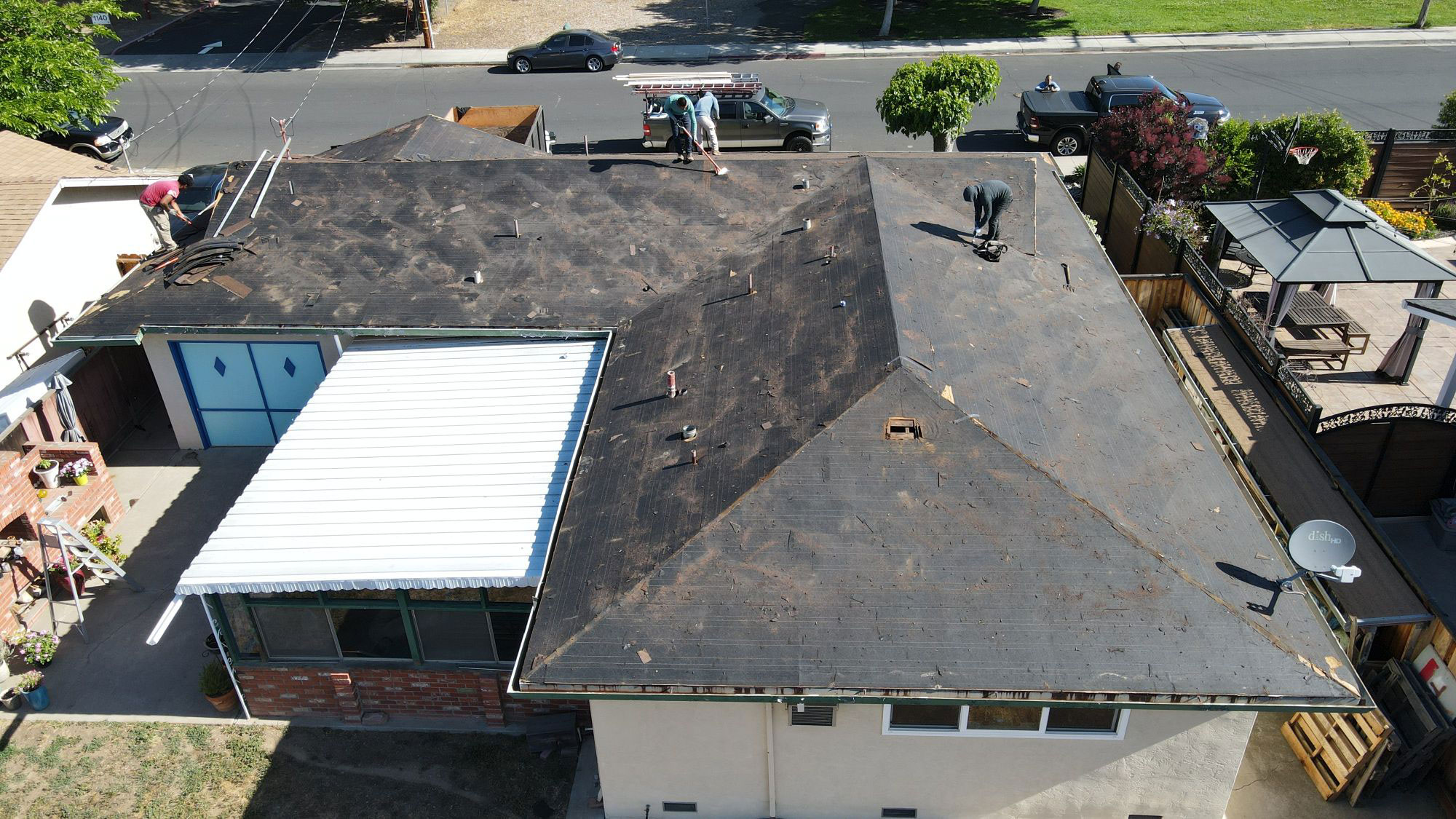 The image shows a residential building with a roof undergoing repair or maintenance.