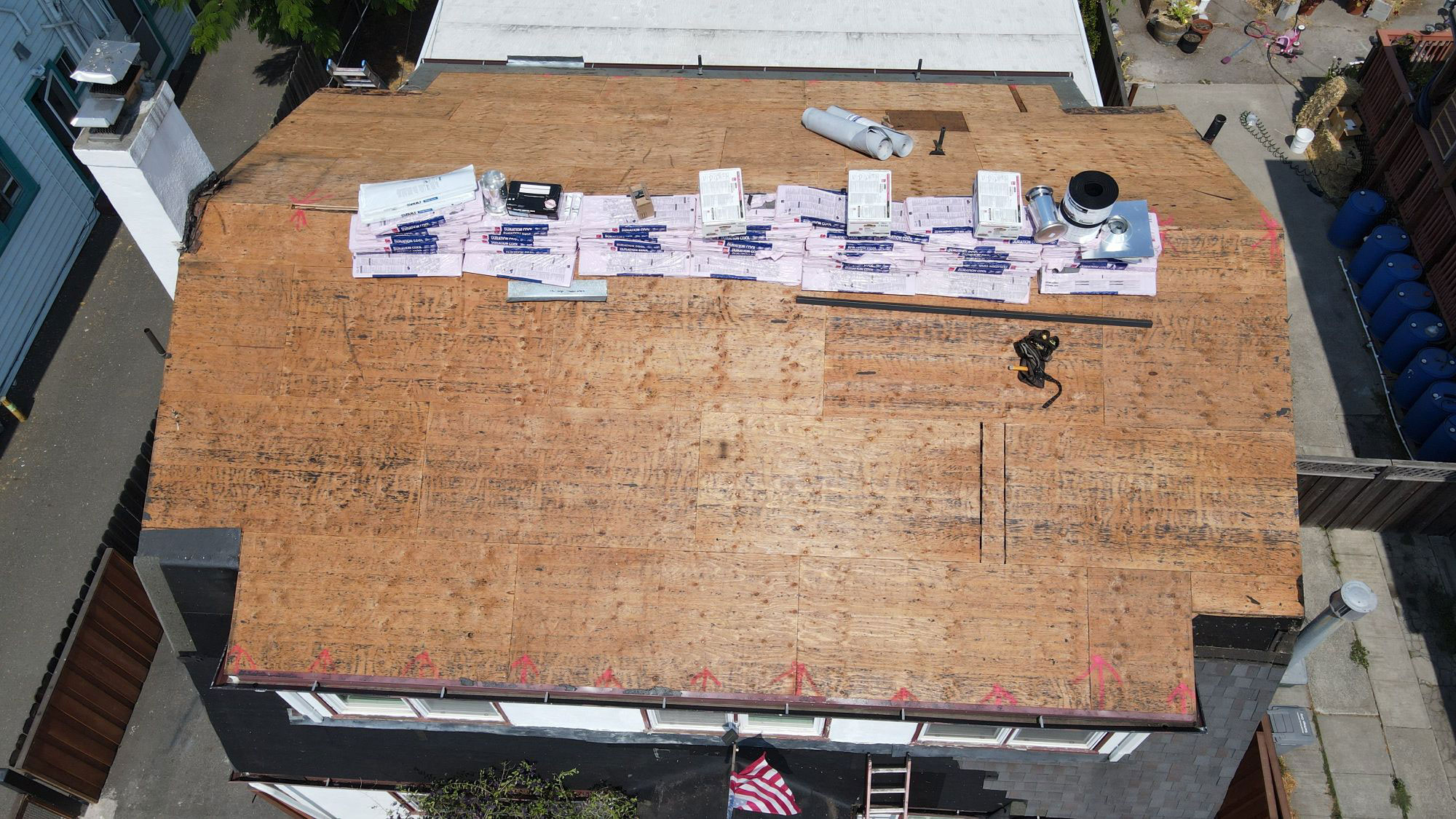 The image shows a roof under construction with visible insulation materials laid out on top.