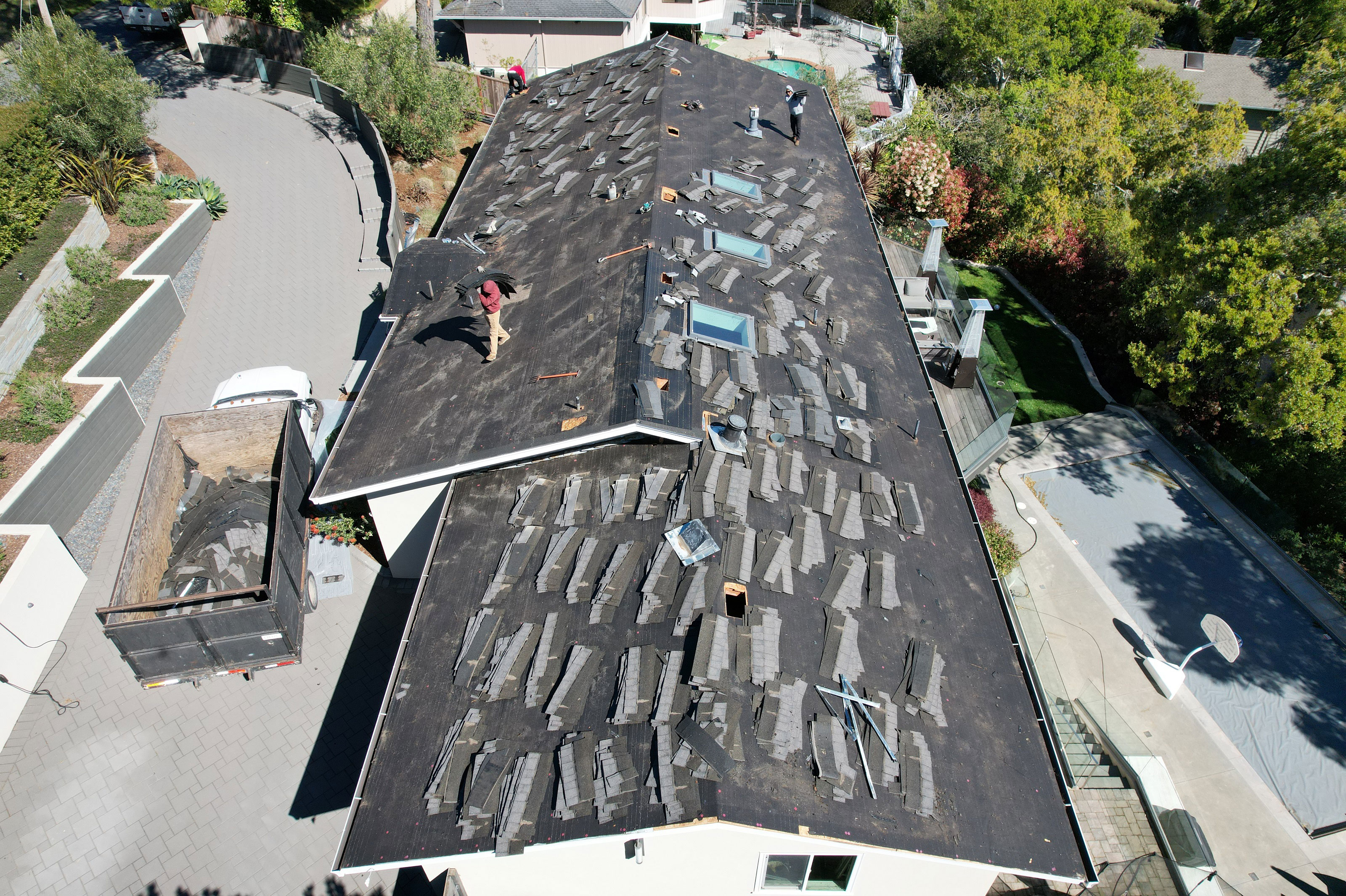 The image shows a building with a partially completed roof undergoing construction work.