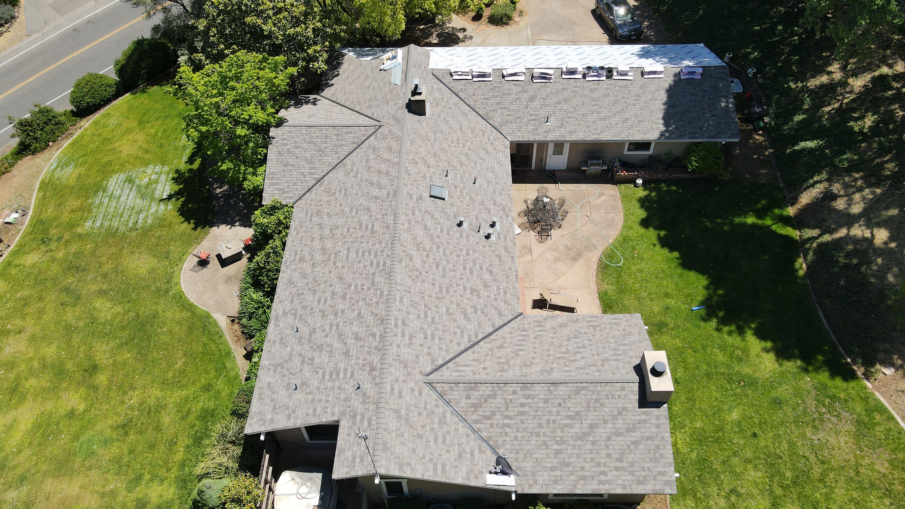 The image shows a residential house with a distinctive roof design, featuring multiple slopes and an unusual pattern.