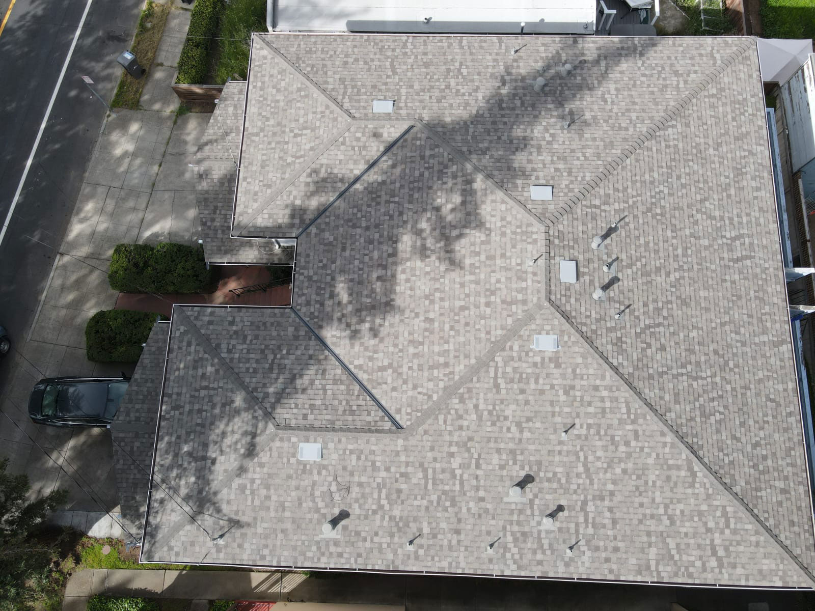 The image shows a close-up view of a section of a gray shingled roof with visible seams where two sections meet.