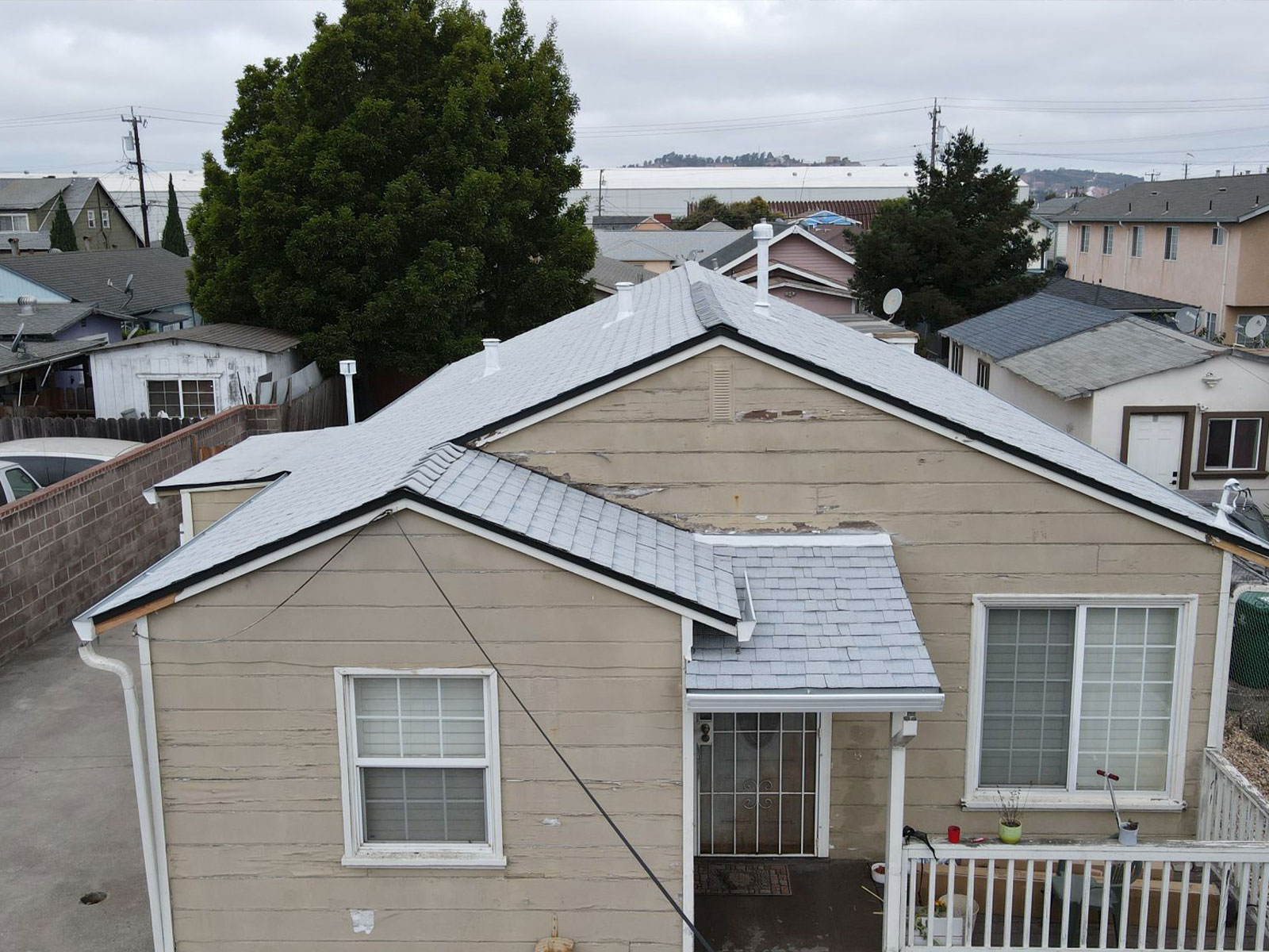 The image shows a single-story house with a flat roof, situated in a residential area.