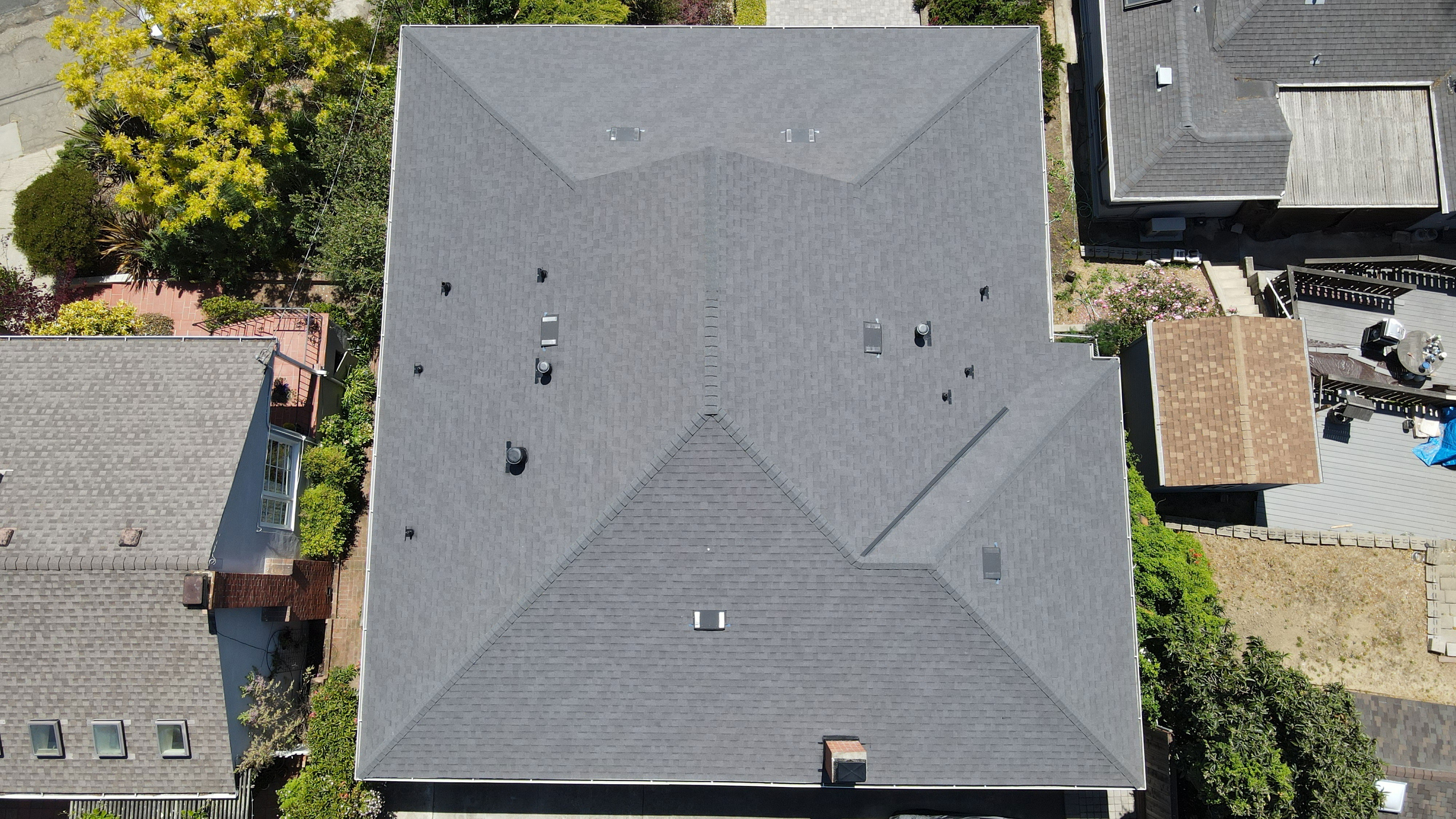 The image shows a roof with multiple skylights on a residential building, viewed from an aerial perspective.
