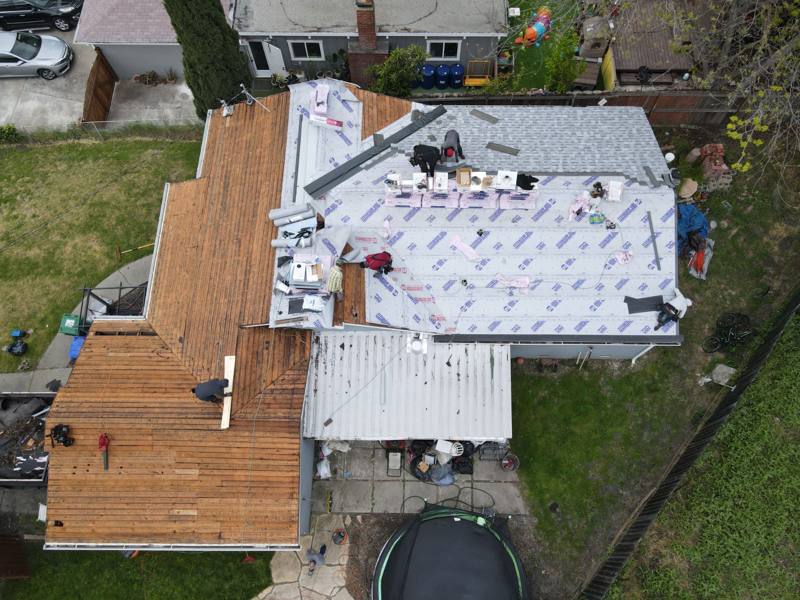 The image shows a house under construction with a roofing project in progress.