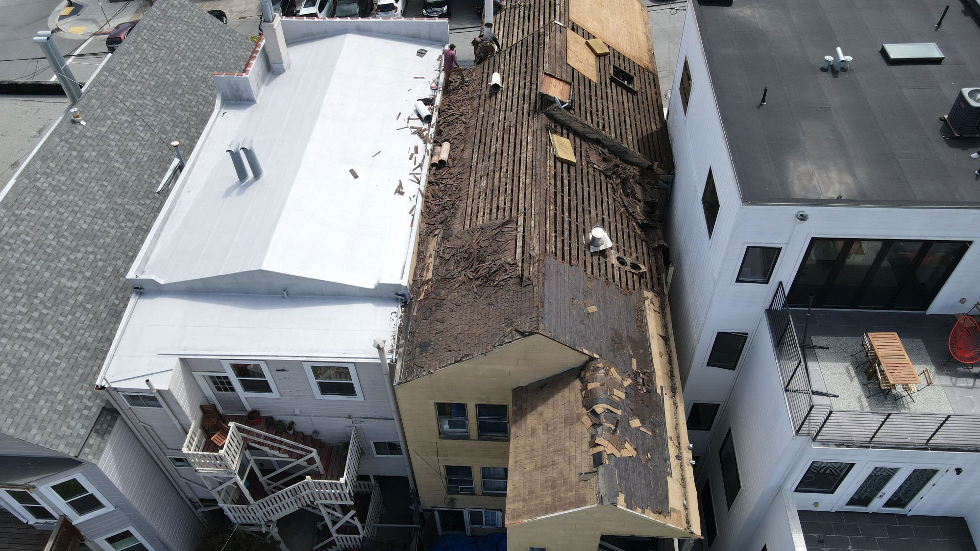 The image shows a building under construction with exposed wooden beams and a partially completed roof structure.