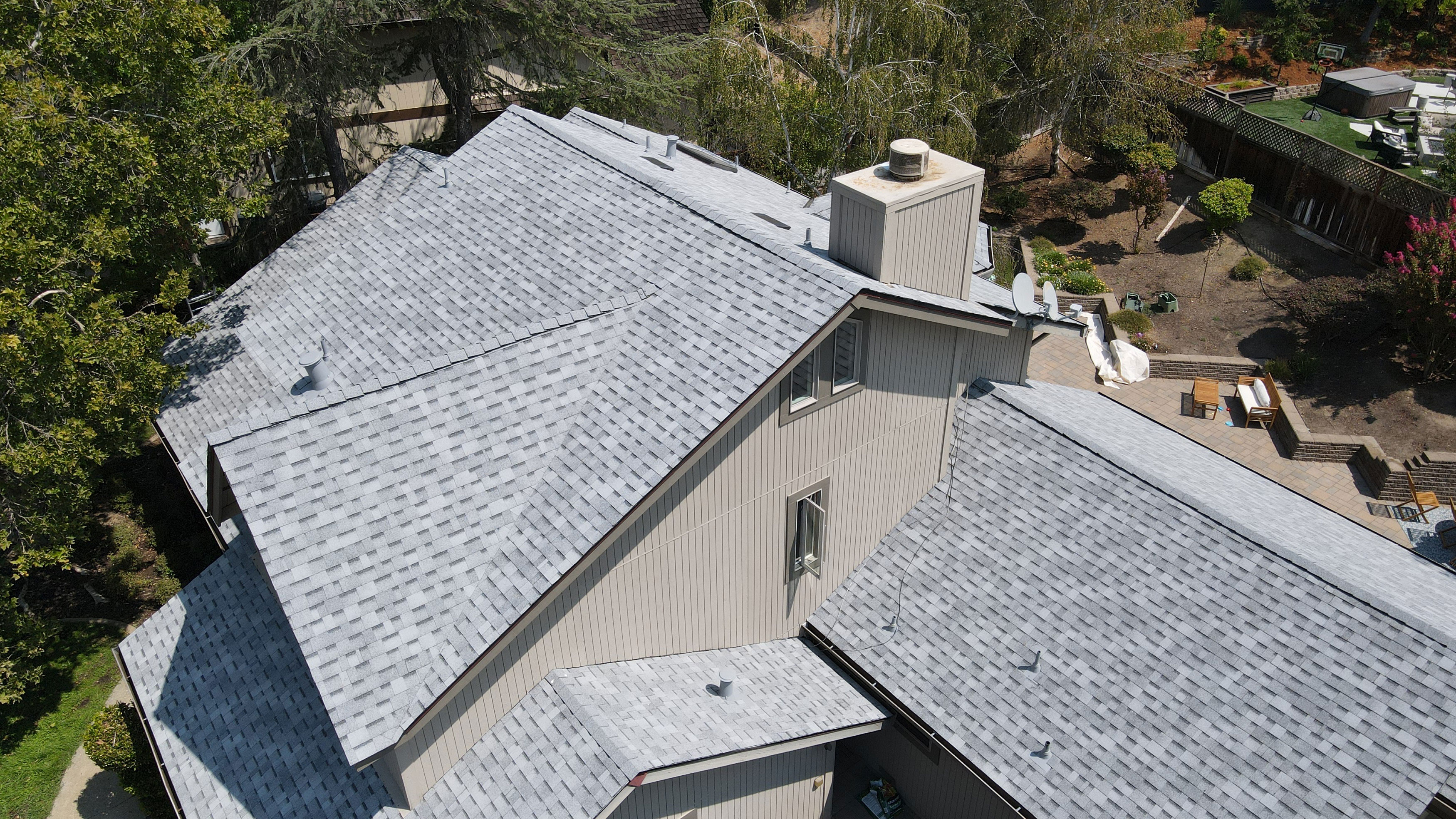 The image shows a single-story residential building with a gray roof and a combination of dark and light siding.