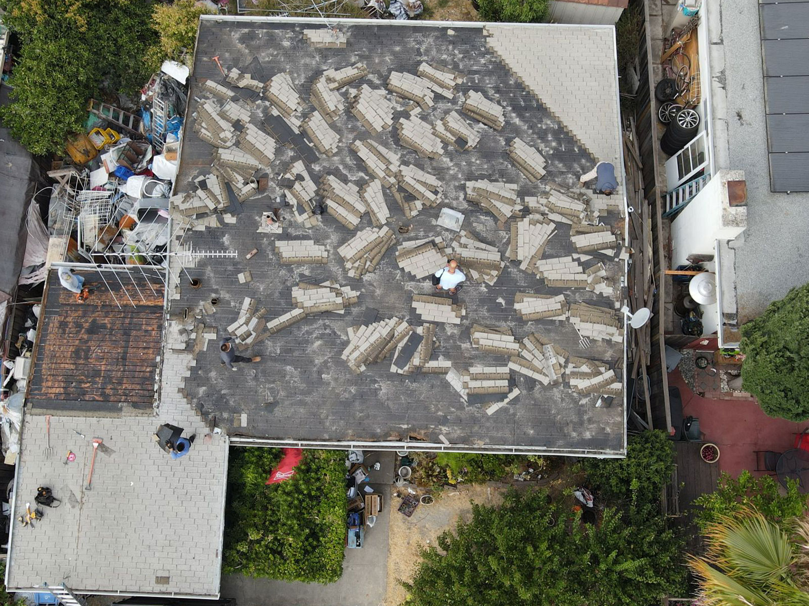 The image shows a rooftop with various objects scattered across its surface, including what appears to be broken tiles and other debris, suggesting ongoing construction or renovation work.