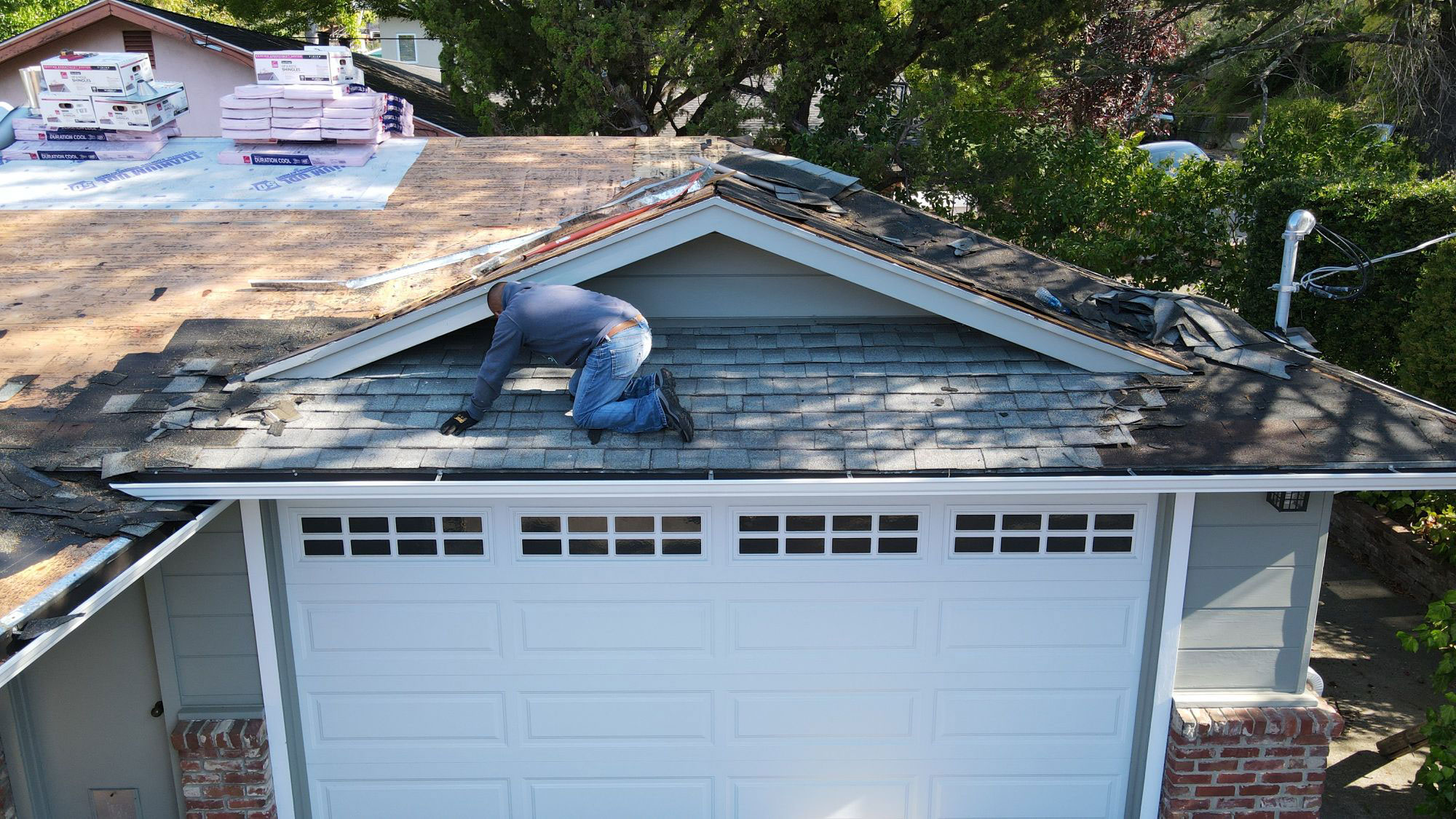 Man working on roof of house.