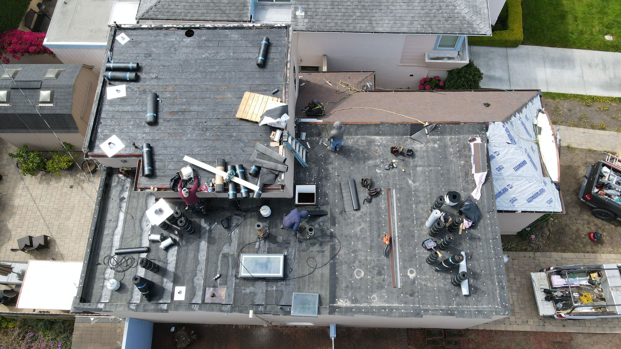 The image shows a building under construction with visible scaffolding and roofing materials, indicating ongoing renovation work.