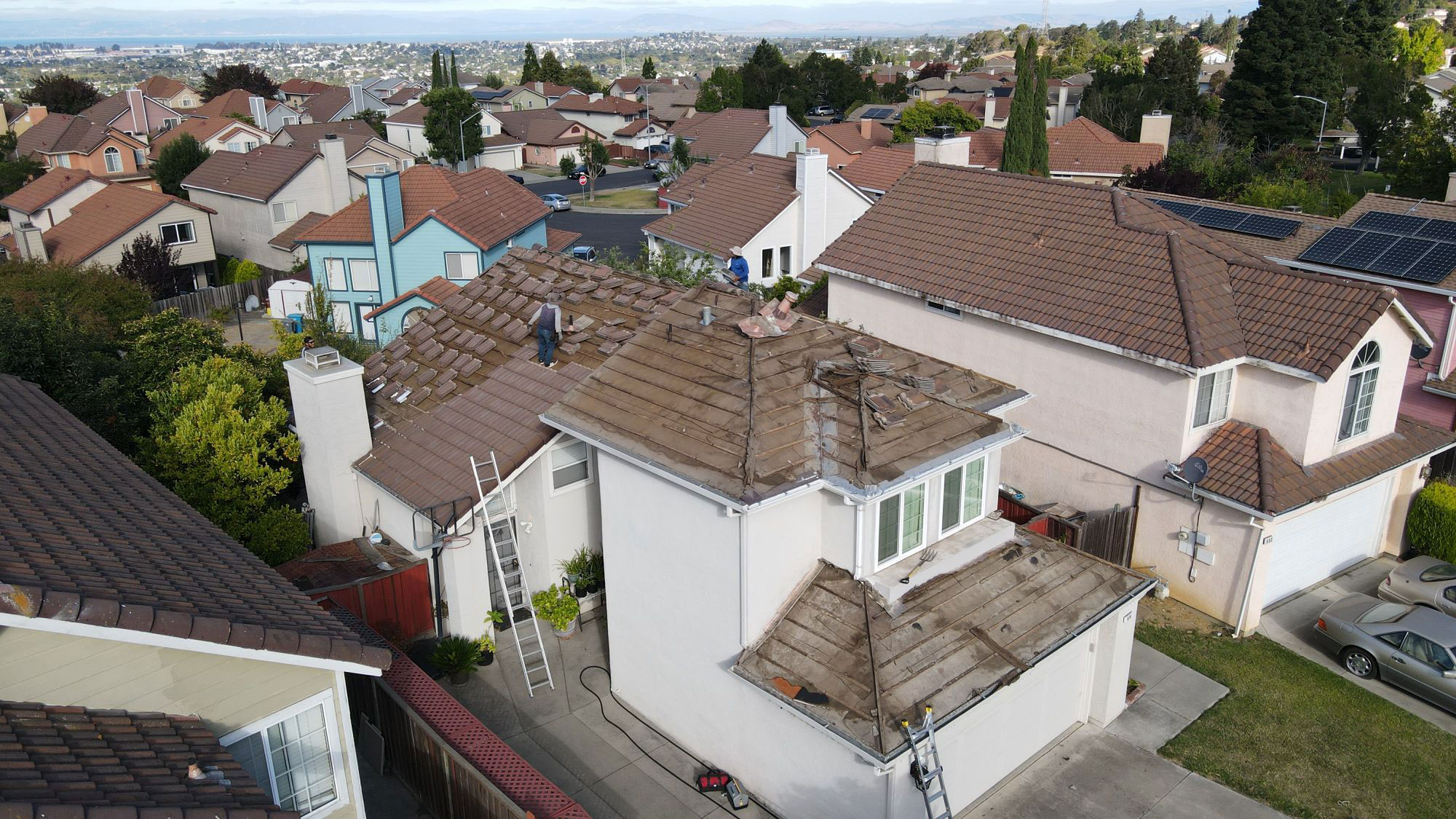 The image shows a residential neighborhood with houses and roofs visible, indicating a suburban setting.