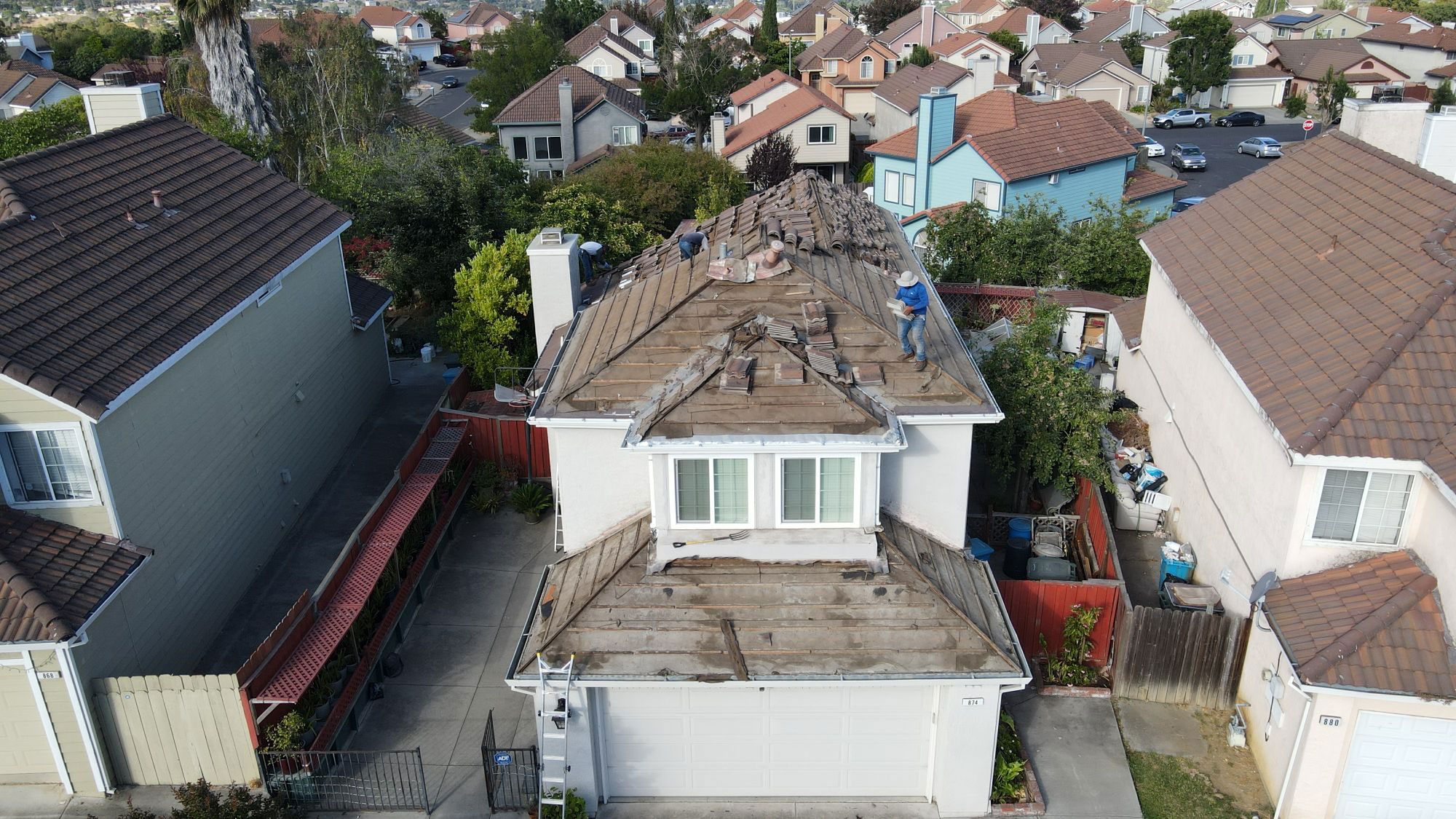 The image shows a residential neighborhood with houses, a street view, and a sky background.