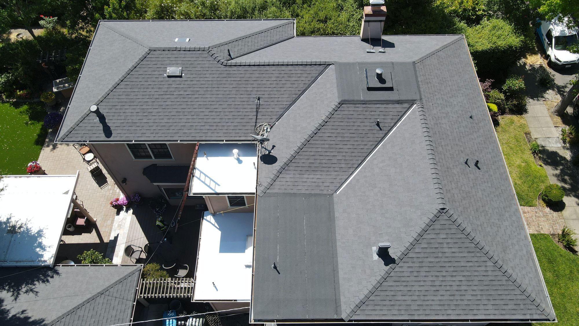 The image shows a roof with a flat profile, featuring gray shingles.