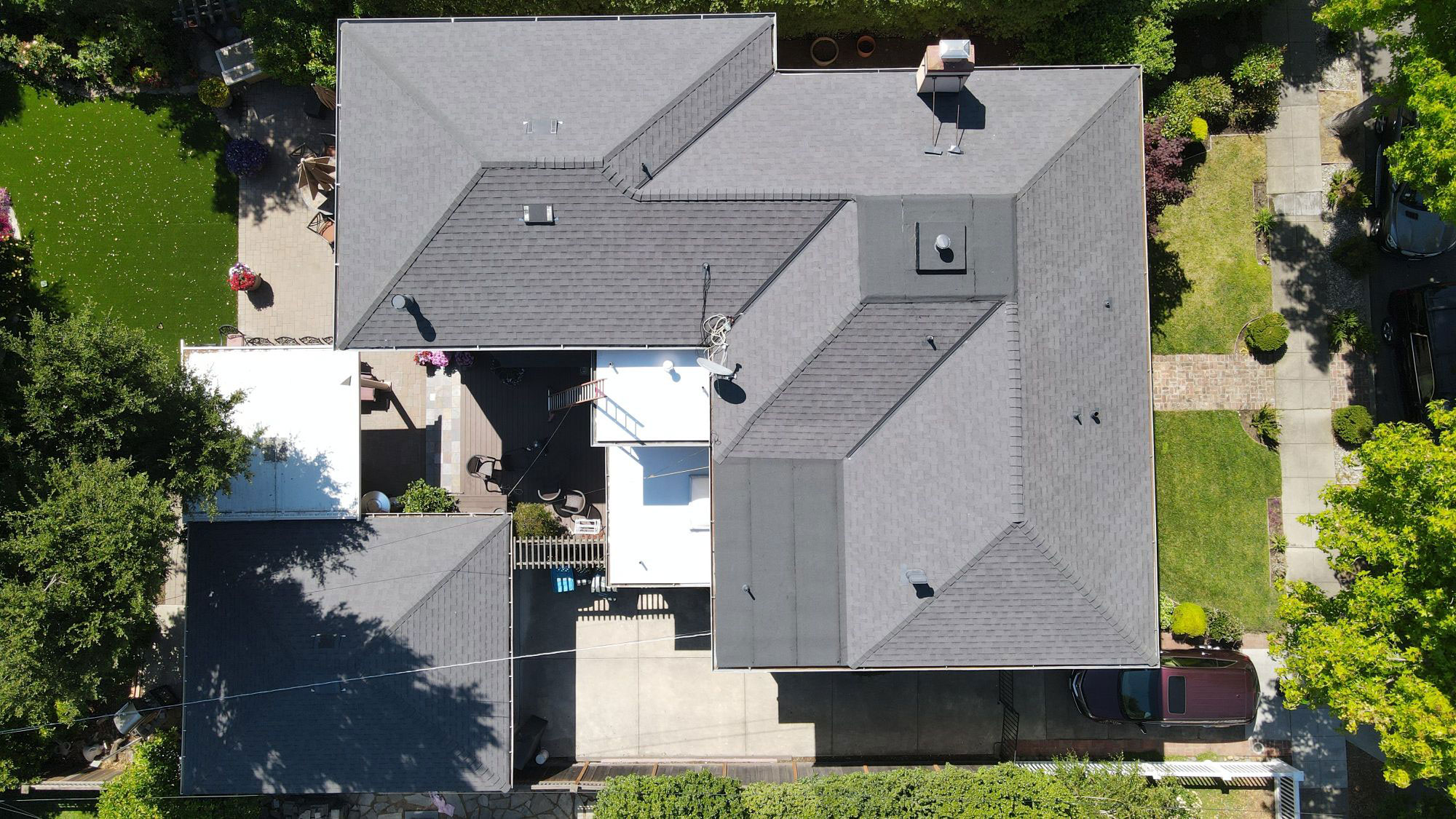 Aerial view of a house with a shingled roof and multiple windows.