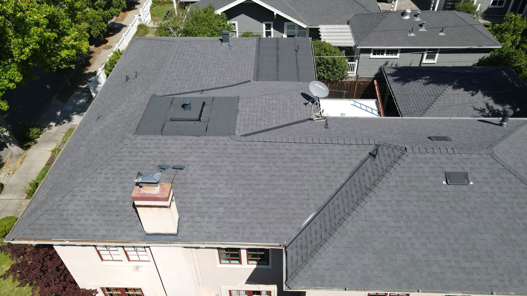 An image of a residential house with a gray roof, showcasing its shingles and the absence of any visible damage or wear.